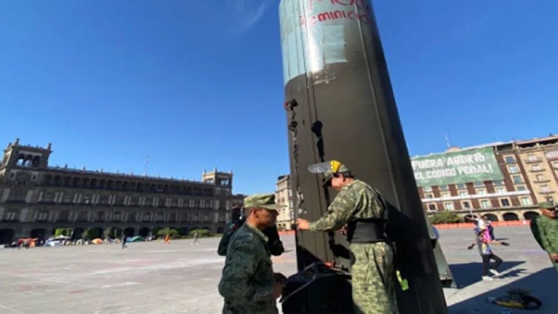 Militares que supervisan la reparación de la asta bandera